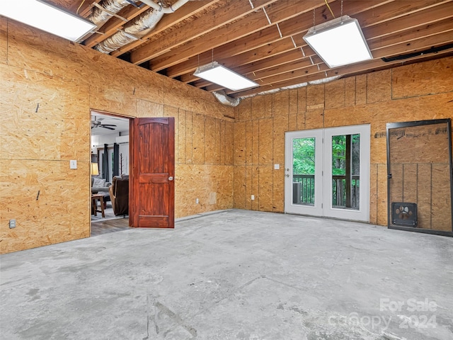 spare room featuring a wood stove, ceiling fan, and concrete floors