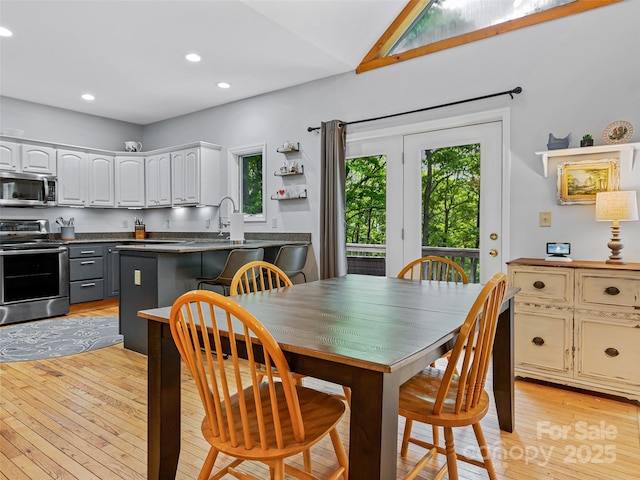 dining room with plenty of natural light, recessed lighting, light wood-style floors, and lofted ceiling
