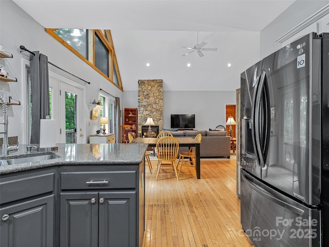 kitchen featuring a ceiling fan, gray cabinetry, stainless steel fridge, and light wood-style flooring