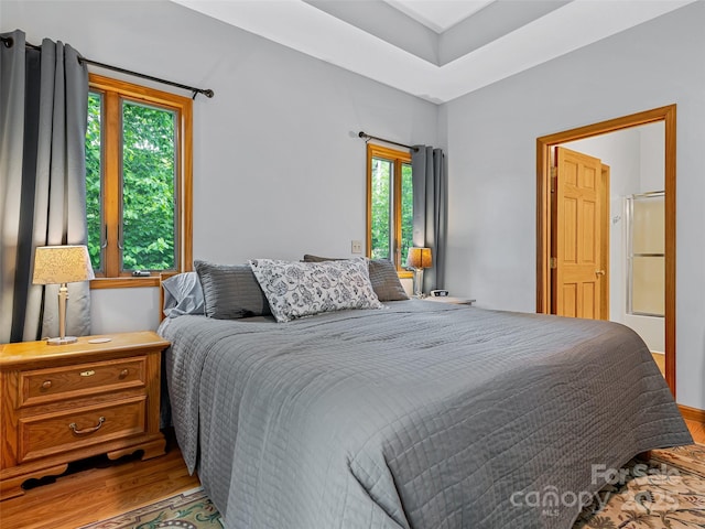 bedroom with multiple windows and wood finished floors