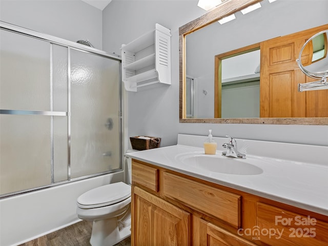 full bathroom with shower / bath combination with glass door, vanity, toilet, and wood finished floors