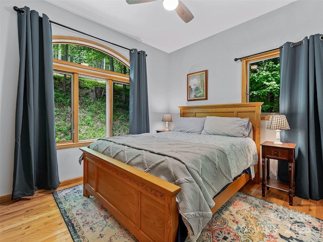 bedroom featuring baseboards, ceiling fan, and light wood-type flooring