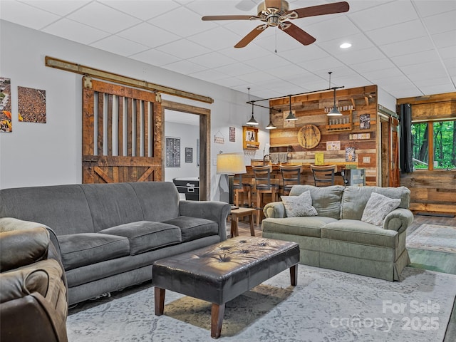 living area featuring wooden walls, a ceiling fan, recessed lighting, and wood finished floors