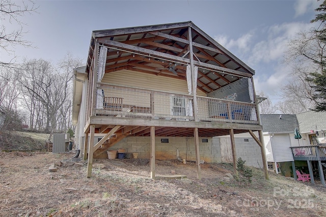 back of house with a wooden deck and cooling unit