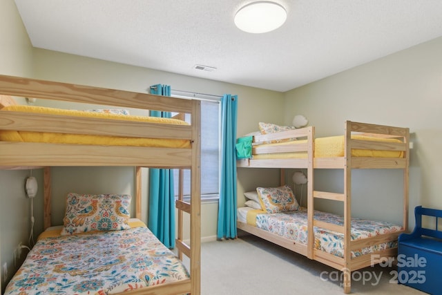 bedroom with carpet floors and a textured ceiling