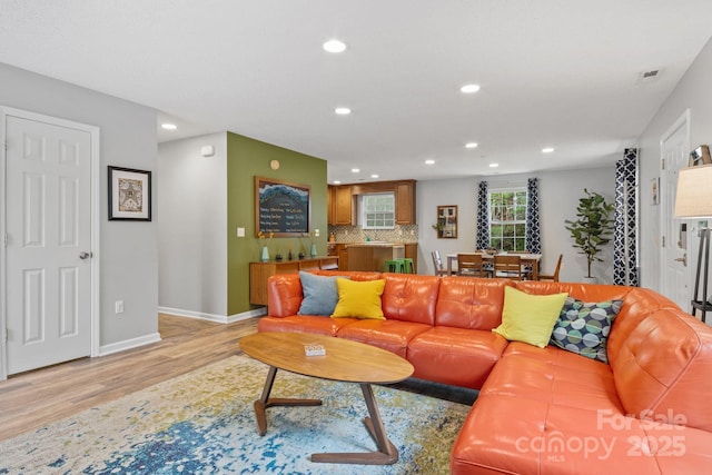 living room with light wood finished floors, recessed lighting, visible vents, and baseboards
