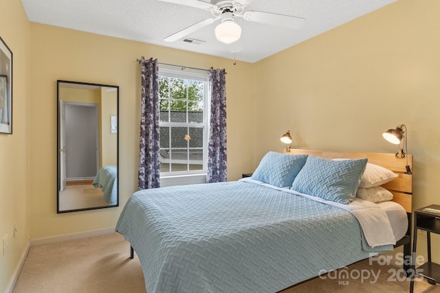 carpeted bedroom with visible vents, ceiling fan, and baseboards