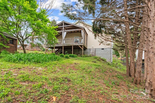 rear view of property featuring crawl space and a wooden deck