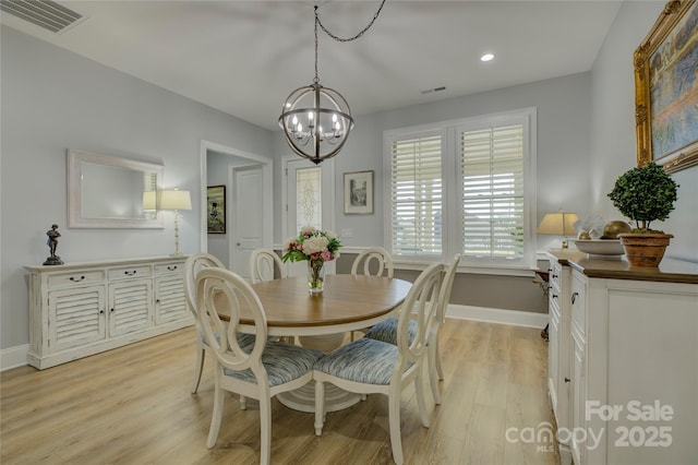 dining room featuring light hardwood / wood-style floors and a chandelier