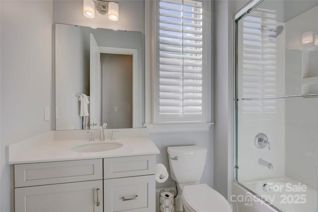 full bathroom with shower / bath combination with glass door, vanity, and toilet