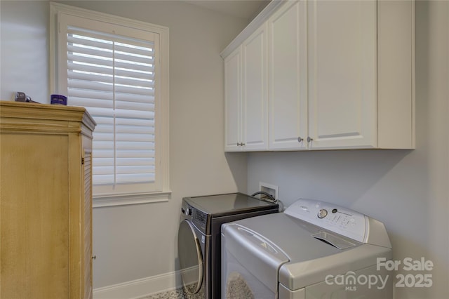 clothes washing area with washer and dryer and cabinets