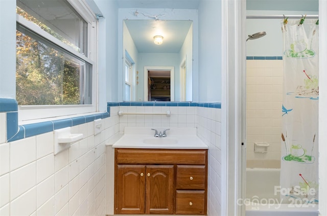 bathroom featuring vanity, shower / bath combination with curtain, and tile walls