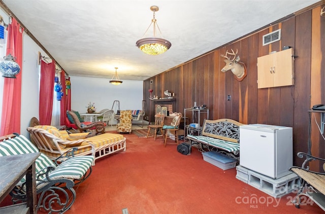 interior space with wooden walls, crown molding, and carpet floors