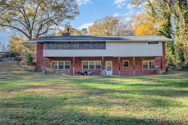 rear view of property featuring a sunroom and a yard