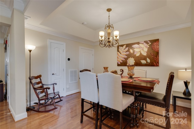 4335 Laurel Hill Ln, Charlotte, NC 28217 - dining space with hardwood / wood-style flooring, an inviting chandelier, ornamental molding, and a tray ceiling