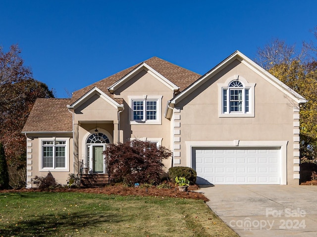 view of property with a front yard and a garage