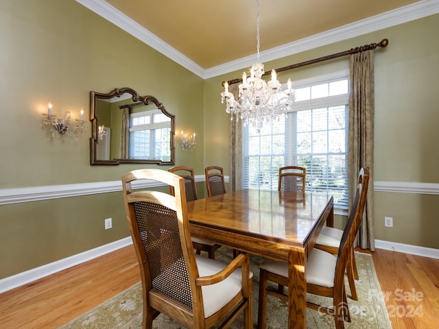 dining room with light hardwood / wood-style flooring, an inviting chandelier, and ornamental molding