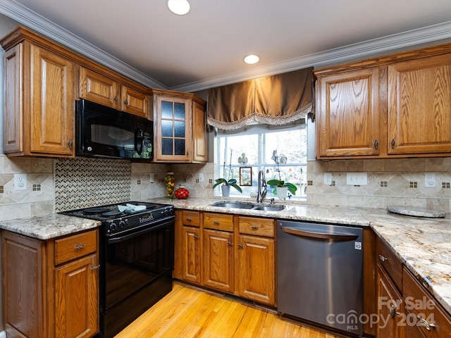 kitchen featuring black appliances, decorative backsplash, light hardwood / wood-style floors, and sink