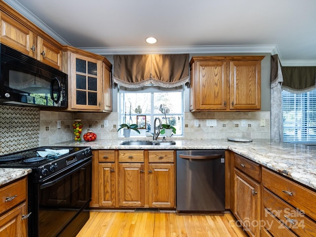 kitchen featuring sink, light hardwood / wood-style flooring, backsplash, black appliances, and ornamental molding