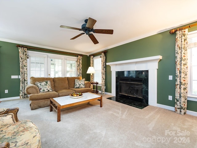 carpeted living room featuring ceiling fan, ornamental molding, and a tiled fireplace