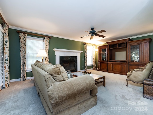 carpeted living room with a high end fireplace, ceiling fan, and ornamental molding