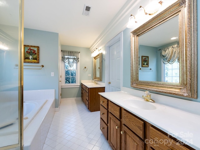 bathroom featuring tile patterned flooring, vanity, and tiled tub