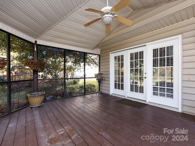 unfurnished sunroom featuring ceiling fan, a healthy amount of sunlight, wood ceiling, and vaulted ceiling