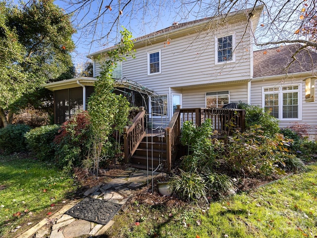 back of house with a sunroom and a wooden deck