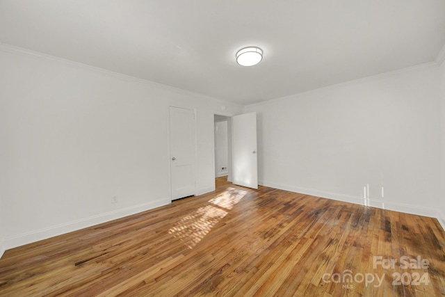 unfurnished room with hardwood / wood-style floors and ornamental molding