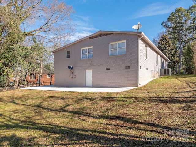 rear view of house featuring a patio, brick siding, and a lawn