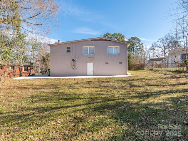 back of property featuring brick siding, a yard, fence, and a patio