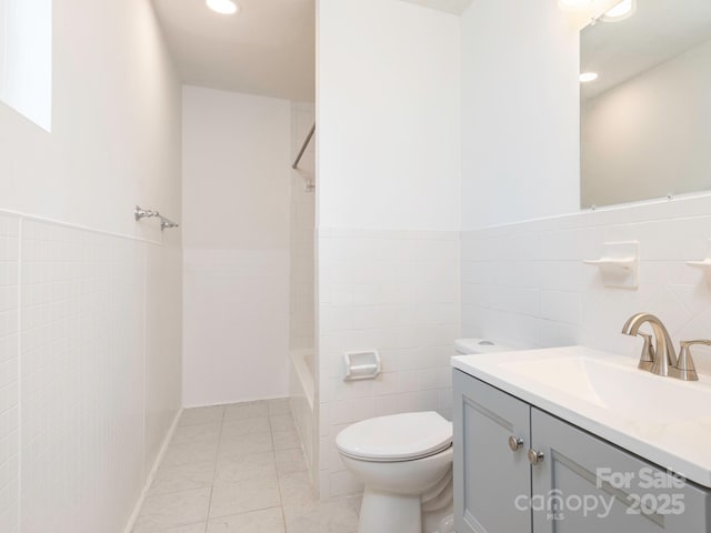 full bathroom with recessed lighting, vanity, toilet, and tile walls