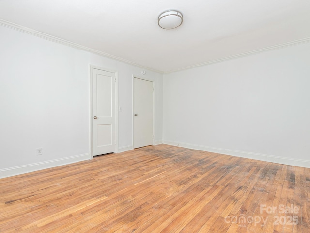 unfurnished room featuring ornamental molding, baseboards, and light wood finished floors