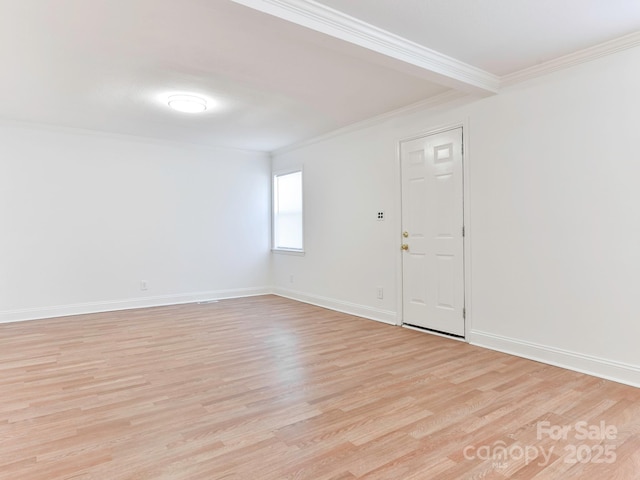 unfurnished room featuring ornamental molding, light wood-style flooring, and baseboards