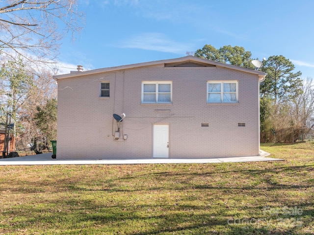 back of house with a yard and brick siding