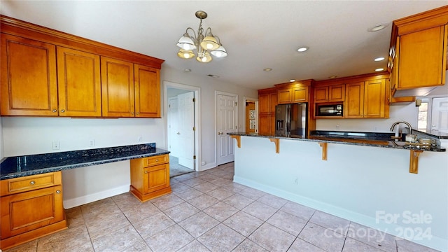 kitchen with pendant lighting, a breakfast bar, dark stone countertops, stainless steel fridge with ice dispenser, and black microwave