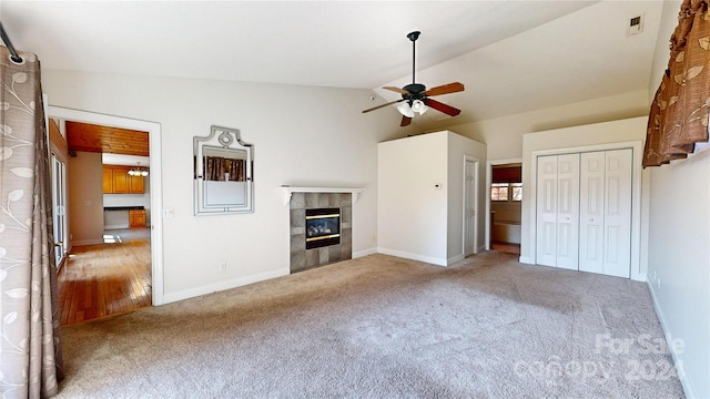 unfurnished living room with ceiling fan, a fireplace, carpet floors, and lofted ceiling