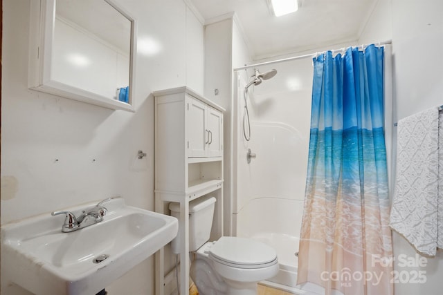 bathroom featuring curtained shower, toilet, sink, and ornamental molding