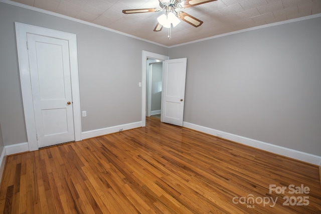 unfurnished bedroom with ceiling fan, crown molding, and wood-type flooring