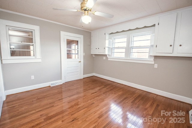 unfurnished room with ceiling fan, wood-type flooring, and ornamental molding