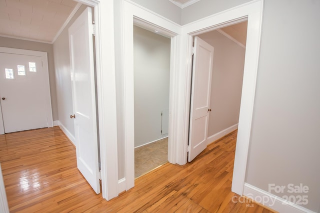 hallway with crown molding and light hardwood / wood-style flooring