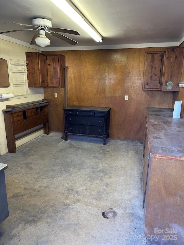 kitchen featuring wooden walls and ceiling fan