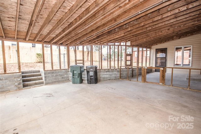 miscellaneous room with concrete floors and lofted ceiling