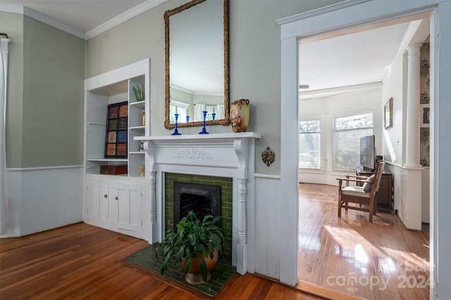 living room featuring hardwood / wood-style flooring, wood walls, ornamental molding, and a brick fireplace