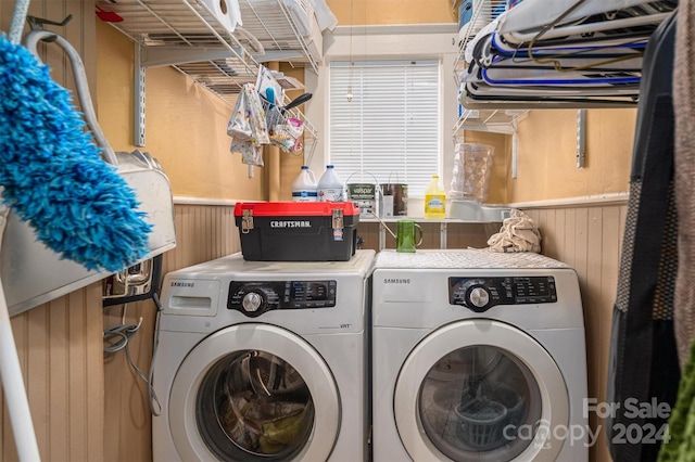 laundry area with washer and dryer and wooden walls