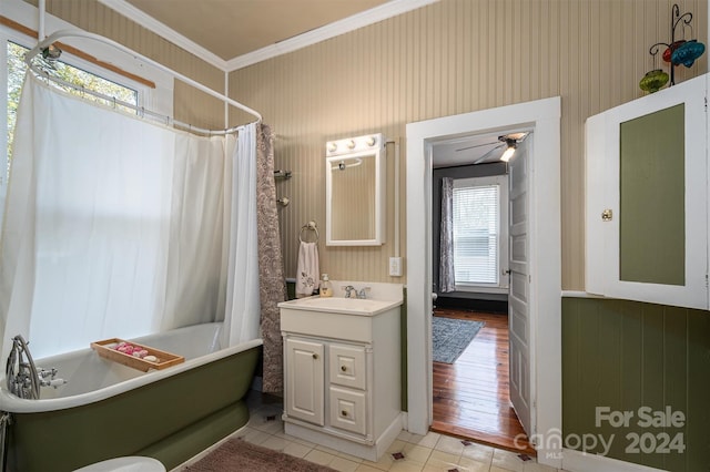 bathroom featuring a wealth of natural light, crown molding, ceiling fan, and wood-type flooring