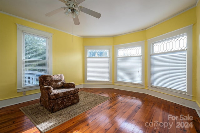 living area with dark hardwood / wood-style flooring, ceiling fan, and crown molding