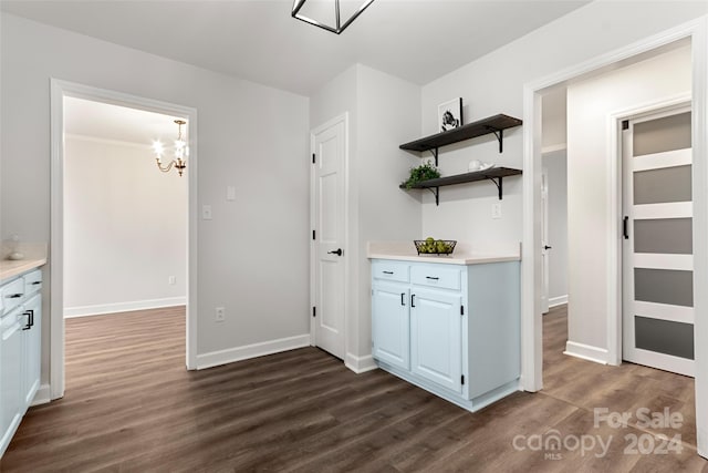 kitchen with a notable chandelier, dark hardwood / wood-style floors, and white cabinetry