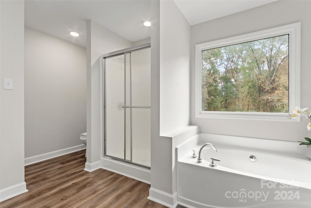 bathroom with toilet, hardwood / wood-style flooring, and separate shower and tub