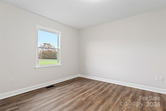 unfurnished room with dark hardwood / wood-style flooring